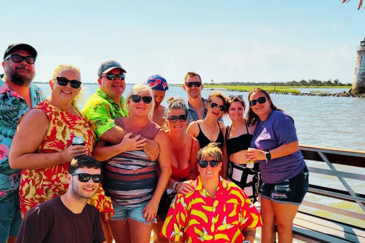 a group of people standing next to a body of water