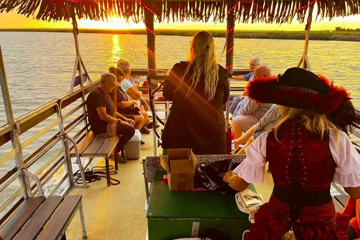a group of people sitting on a bench next to a body of water