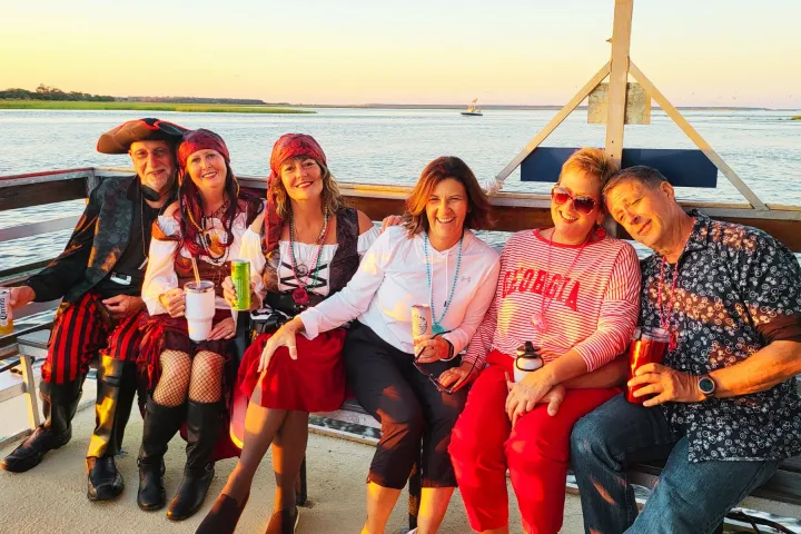 a group of people sitting next to a body of water