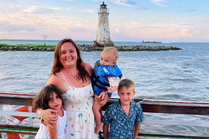 a little girl standing in front of a body of water