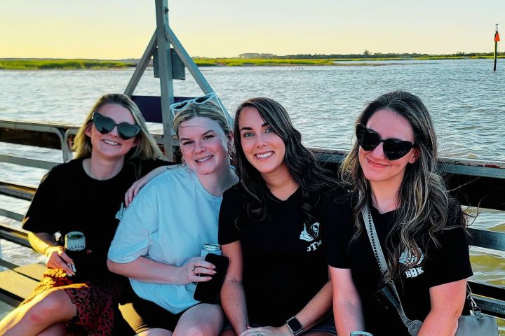 a group of people sitting on a bench next to a body of water