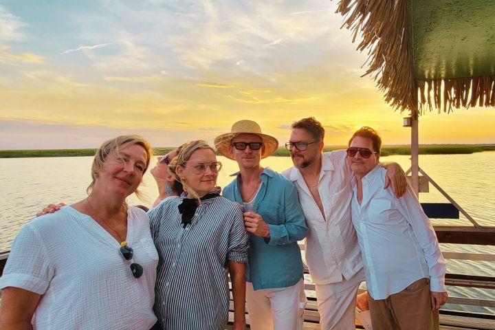 a group of people posing in front of a body of water