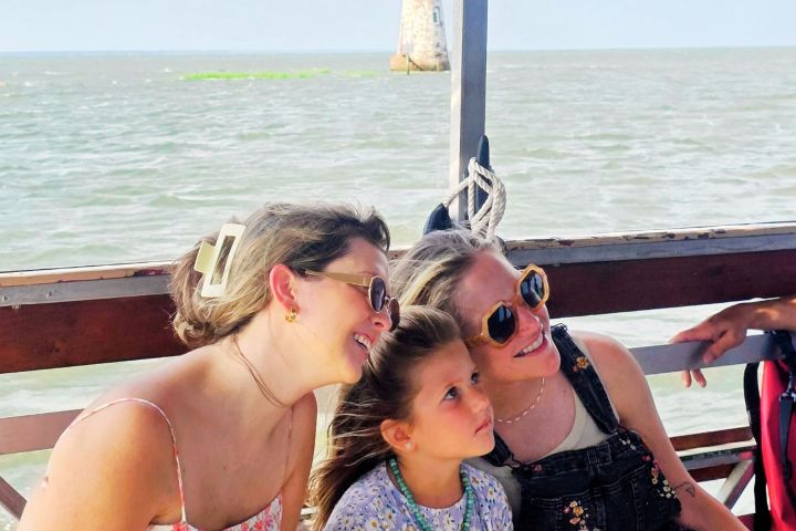 a woman sitting next to a body of water