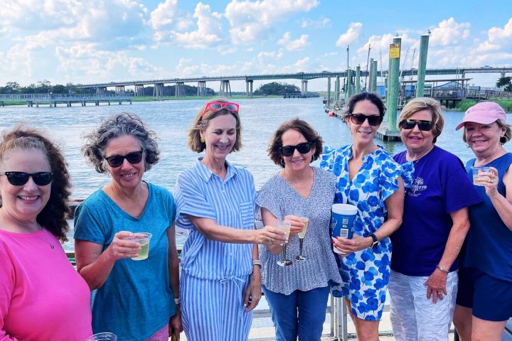 a group of people standing in a body of water posing for the camera