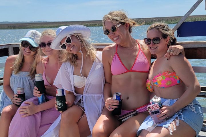 a group of people sitting next to a body of water