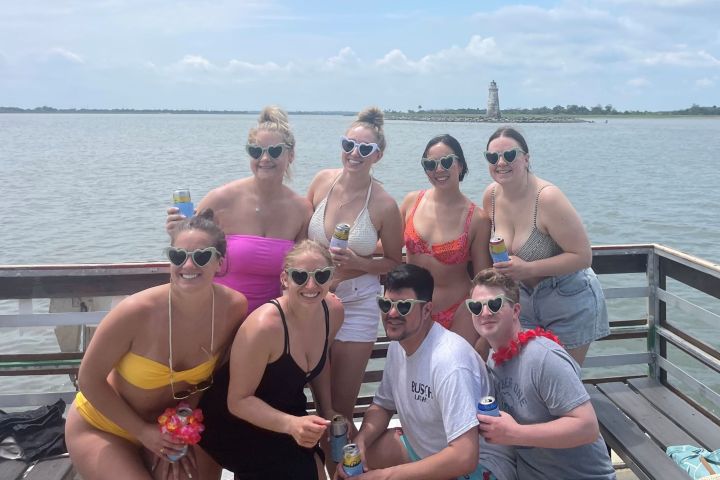 a group of people posing in front of a body of water